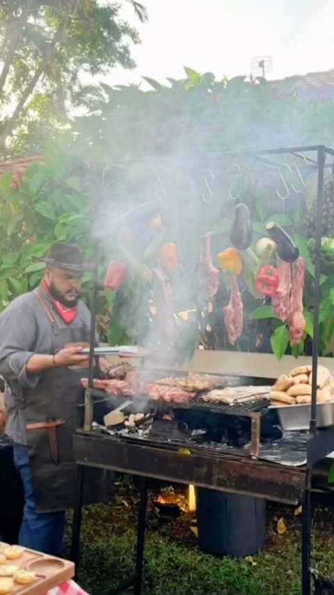 Parrilla montada com carnes e legumes em evento ao ar livre